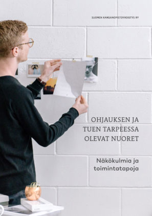 Ohjauksen ja tuen tarpeessa olevat nuoret -julkaisun kansikuva. Nuori mies kiinnittää lappua seinään.