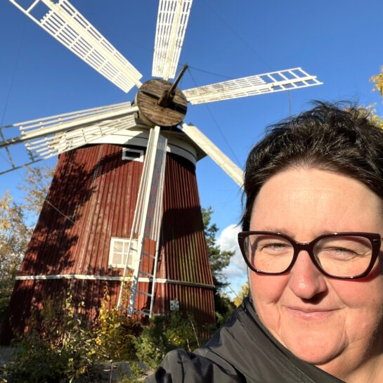 Pohjanmaan Sosialidemokraatit ry:n toiminnanjohtaja Johanna Autio taustanaan tuulimylly